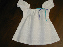 Load image into Gallery viewer, Photo of white eyelet Mexican Baby Dress. View is from front and dress is laying flat on a wood floor