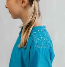 Load image into Gallery viewer, Close up photo of shoulder of smock and details of decorative stitching on shoulder panel.