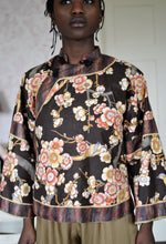 Load image into Gallery viewer, Black woman wearing a short, floral Chinese Jacket with striped facings.