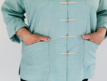 Load image into Gallery viewer, Close up of hands in the pockets of the Chinese pajama Jacket in light blue