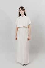 Load image into Gallery viewer, Woman wearing a white cheongsam standing in front of a white background.