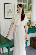 Load image into Gallery viewer, Woman wearing a white cheongsam standing on a porch.