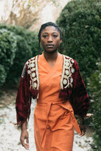 Load image into Gallery viewer, Woman walking outdoors with snow covered ground. Wearing the traditional jacket view A open front showing bead work.