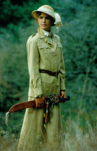 Load image into Gallery viewer, Woman standing in tall grass wearing 130 Jacket and 209 Walking Skirt. Model holds an machete in hands and wears a sun hat.
