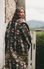 Load image into Gallery viewer, Photo of woman wearing view b of Hungarian Szur. woman is walking and looking back over her shoulder. Picture shows back collar lapel extending over shoulder to front of jacket.