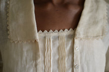 Load image into Gallery viewer, Close up of 210 Armistice Blouse long collar forming a deep rectangle, trimmed with lace at the edges of the collar worn by African woman