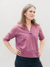 Load image into Gallery viewer, White woman standing slightly turned to the right with hands on her hips wearing the 211 Two middies v-neck.