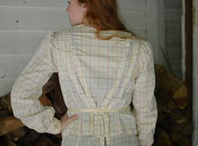 Load image into Gallery viewer, Back view of young red head woman standing with one hand on her hip wearing 216 Schoolmistresses Shirtwaist and skirt. the shirt is gathered in the back and tied at the waist.