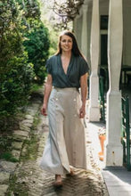 Load image into Gallery viewer, Photo of model wearing a short sleeve version of Thai Blouse. Model walks outdoors and wears top with 231 Big Sky Riding Skirt.