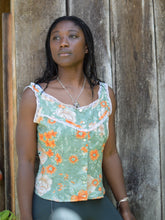 Load image into Gallery viewer, african american woman standing in front of a wood wall wearing a floral green and orange sleeveless camisole.