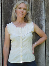Load image into Gallery viewer, white blonde woman standing in front of a wooden wall with left hand on her hip wearing sleeveless cameo in beige with beige lace embellishment
