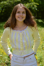 Load image into Gallery viewer, young white woman wearing a pastel long sleeved camisole with pastel purple lace. hands in the back of her pockets and smiling. With greenery in the background.