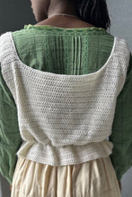 Load image into Gallery viewer, Black woman wearing a cream quilted skirt with a green blouse and white crocheted camisole on top - close up of the back - in front of a grey wall.