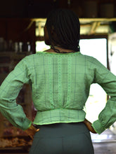 Load image into Gallery viewer, Back of African American woman standing with hands in her hips wearing a green check 234 long sleeved version camisole.
