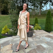Load image into Gallery viewer, Woman standing on a patio outside wearing a gold tango dress and black and gold heels.