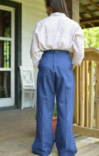 Load image into Gallery viewer, Back view of a young girl wearing the 240 Rosie the Riveter slacks and shirt, standing on a porch.