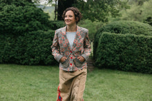 Load image into Gallery viewer, Young brunette woman smiling walking surrounded by greenery wearing the 242 Rodeo Cowgirl Jacket with hands in the pockets.