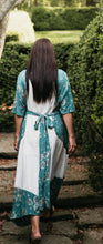 Load image into Gallery viewer, brunette woman walking up steps surrounded by greenery showing the back view of the Paris Promenade Dress.