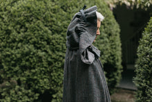Load image into Gallery viewer, Close up of older white woman standing surrounded by greenery wearing 207 Kinsale Cloak with hood up.