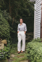 Load image into Gallery viewer, Young brunette white woman walking surrounded by greenery, wearing the Rosie the Riveter slacks and shirt.