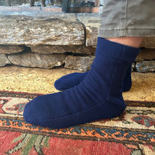 Load image into Gallery viewer, navy blue polar slippers ono feet by a rug and stone hearth