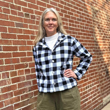 Load image into Gallery viewer, Woman standing in front of a brick wall wearing a black and white buffalo plaid polar lodge jacket.