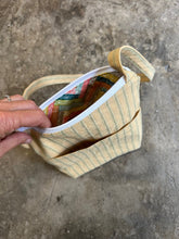 Load image into Gallery viewer, Hand holding a colorful fabric item against a concrete background