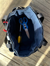 Load image into Gallery viewer, Open blue tool bag with tools inside on a wooden surface