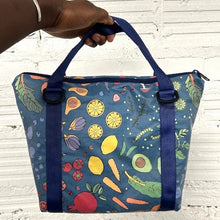Load image into Gallery viewer, image of lunch tote made with blue fabric printed with vegetables and frult and with blue handles