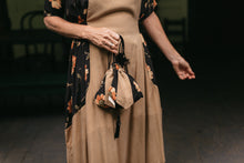 Load image into Gallery viewer, Close up from the waist down of the front Promenade Dress with the drawstring bag held in front.