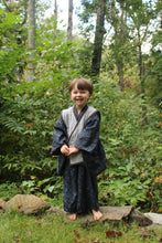 Load image into Gallery viewer, Child standing in a forest with greenery and trees in the background