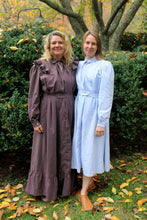 Load image into Gallery viewer, To women wearing a brown and blue Calico Day Dress, standing by a tree and bush outside.