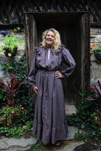 Load image into Gallery viewer, Brown calico day dress on a woman standing by a doorframe with flowers