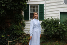 Load image into Gallery viewer, Smiling woman standing in front of a white house in a blue dress
