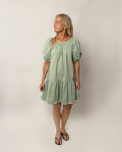 Load image into Gallery viewer, Woman wearing a green dress with puff sleeves against a plain background