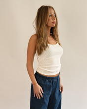 Load image into Gallery viewer, Woman wearing a white top and blue pants against a plain background