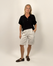Load image into Gallery viewer, Person wearing a black shirt and striped shorts on a plain background