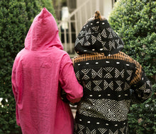 Load image into Gallery viewer, Back view of two women arms linked, surrounded by greenery wearing the Moroccan Djellaba with the hoods.