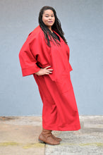Load image into Gallery viewer, An African American woman, with hand on her right hip wearing the Basics Overcoat in a Scarlett Red wool.