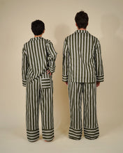 Load image into Gallery viewer, Two models shown from the back wearing matching striped pajama sets in olive green and white, standing against a plain beige studio background.
