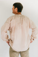 Load image into Gallery viewer, Man wearing striped French Cheesemakers Smock standing in front of white background. His back is turned toward the camera.

