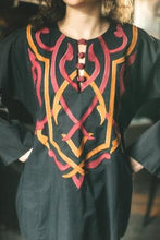 Load image into Gallery viewer, Close up photo of model in black Egyptian top.  Applique covers top from neckline to waist.  Four buttons are at closure of neckline slit.  Applique is two colors gold and coral.
