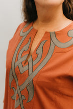 Load image into Gallery viewer, Woman in coral Egyptian Shirt.  Close up of front yoke with neck slit and gray applique.
