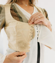 Load image into Gallery viewer, Close up photo of the button loops on the vest.  vest is over the jacket and tunic.  It is unbuttoned and model holds out the closure to show details.
