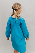 Load image into Gallery viewer, Photo of young girl wearing a blue corduroy Smock. Model had back to camera.  Photo shows gathering at neckline and back view.
