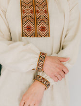 Load image into Gallery viewer, Close up photo of embroidery on neck opening and cuffs of View B.
