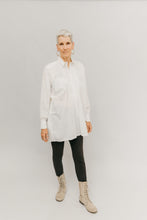 Load image into Gallery viewer, Woman standing in front of light grey background wearing a white Croatian shirt as a tunic with black leggings and boots.

