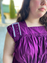 Load image into Gallery viewer, Young woman wearing a purple sleeveless dress with some embellished shoulder yoke.

