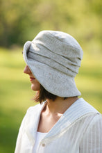 Load image into Gallery viewer, the left side view of young brunette white woman in a white blouse wearing the Metropolitan hat.
