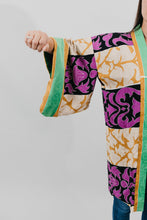 Load image into Gallery viewer, Asian woman wearing a purple, black, green, and gold printed Haori - close up of the sleeve.
